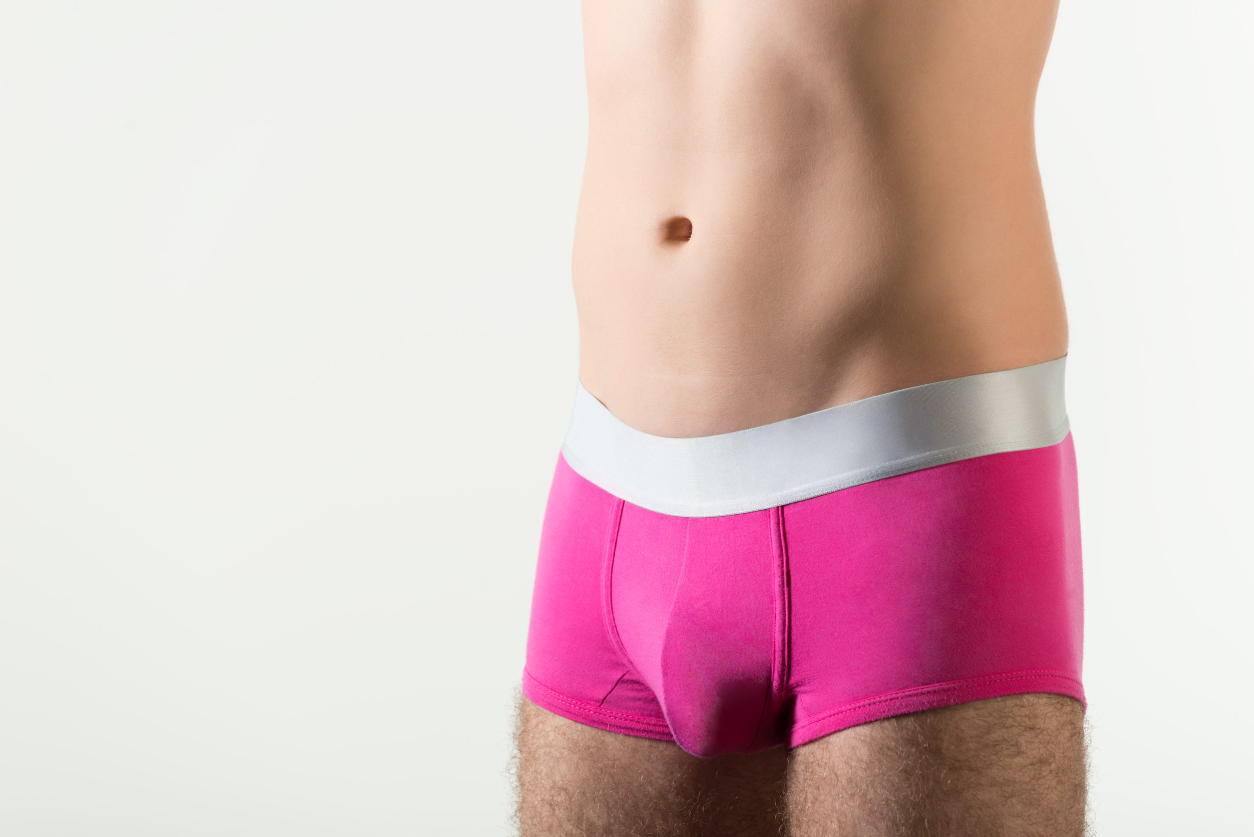 A man's mid-section is shown in hot pink boxer briefs as he prepares for sissy training.