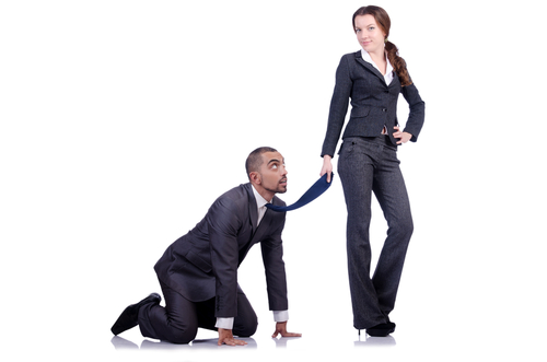 Corporate pig, a woman in a suit dominating a business man in a suit